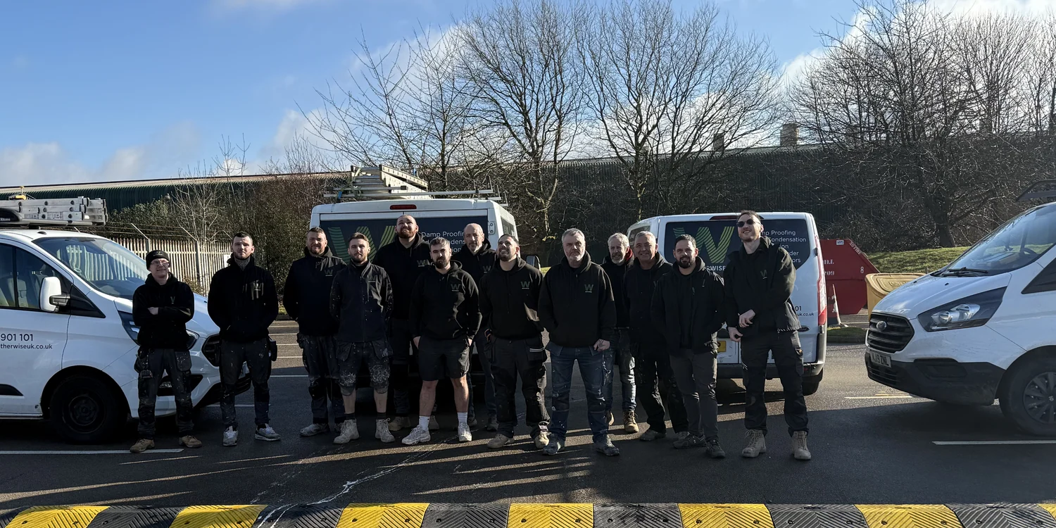 The Weather Wise field team standing with branded service vehicles